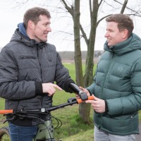 Abb. 2 Der leidenschaftliche Quad- und Fahrradfahrer Sebastian Fenske (l.) im Gespräch mit Orthopädietechnik-Meister Bernhard Oelßner (r.) über den Sitz des Prothesenadapters für sein Bike.