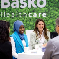Conversation situation at the trade fair stand: six people laughing at each other.