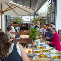 People standing at a buffet.