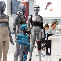 Exhibition booth at OTWorld featuring futuristic mannequins displaying orthopedic and medical assistive devices.