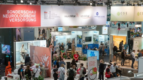 Overview of the special exhibition ‘Neurological Care’ at OTWorld with numerous visitors, information booths, and interactive presentations.
