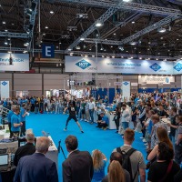Large audience watches a live athletic demonstration at the Wilhelm Julius Teufel GmbH booth at OTWorld, surrounded by industry exhibitors and technology