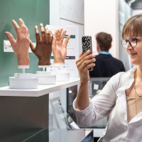 A visitor takes a photo of lifelike prosthetic hand models at OTWorld.