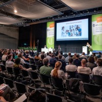 Congress situation: A lecture is taking place on the stage in the congress hall, with a large audience sitting in front of it.
