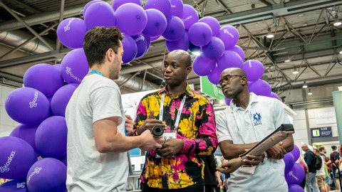 International expert discussions at OTWorld - exchange on innovations against a creative backdrop of purple balloons.