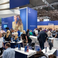 Knee joint orthoses are presented at a well-attended trade fair stand.